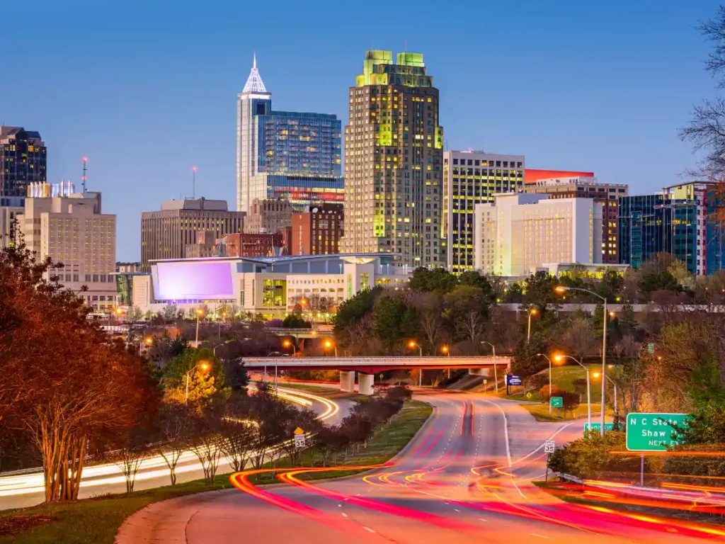 Downtown Raleigh, NC skyline at dusk with highway light trails in the foreground
